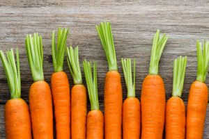 Fresh carrots bunch on rustic wooden background.